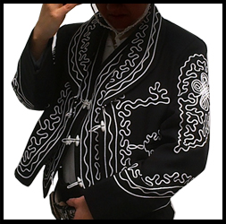 Traje de charro o mariachi color negro con adornos en blanco.